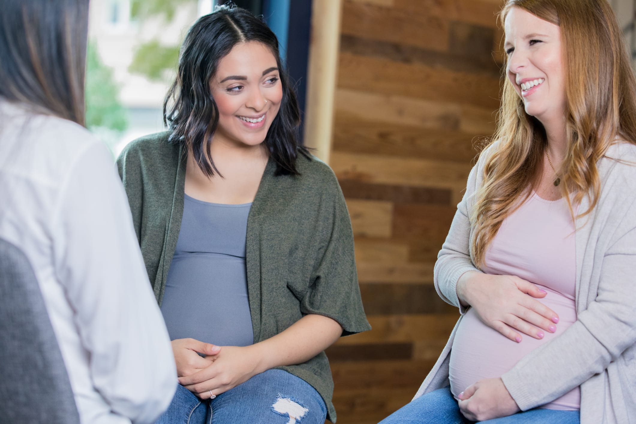 CenteringPregnancy-Womens-Services Two expectant mothers are discussing their pregnancies during a prenatal support group meeting.