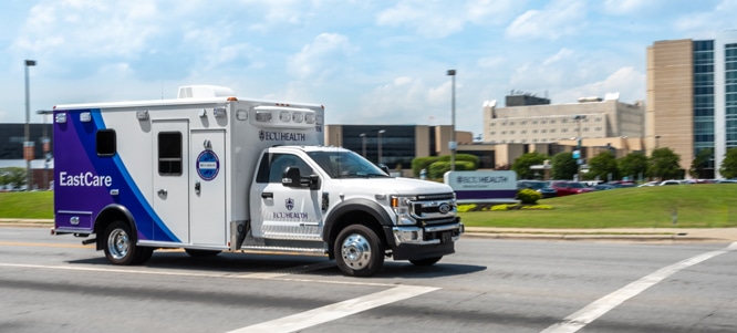 An ECU Health EastCare ambulance drives down the road.