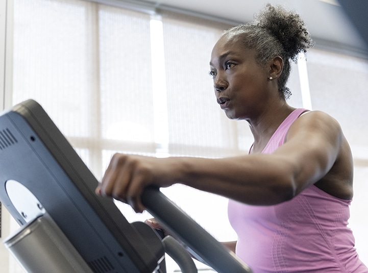 Mature woman exercising on elliptical machine