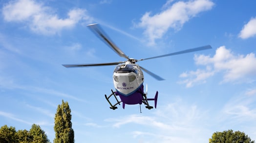 An ECU Health EastCare helicopter flies overhead.