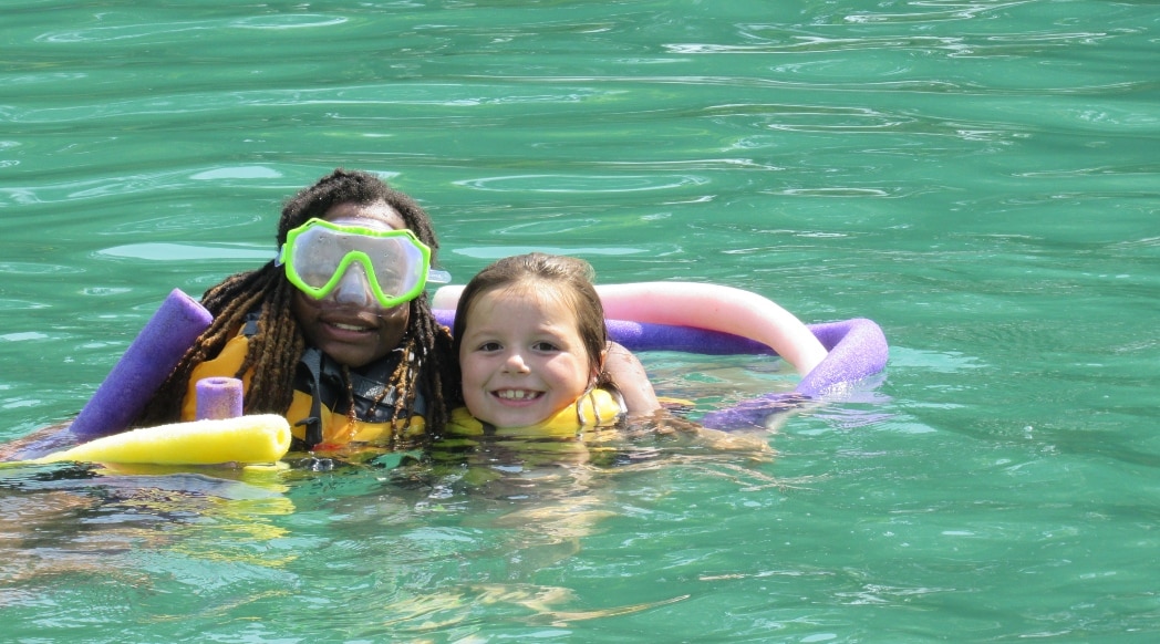 Camp Photo 3 edit Two campers swim while attending a summer camp.