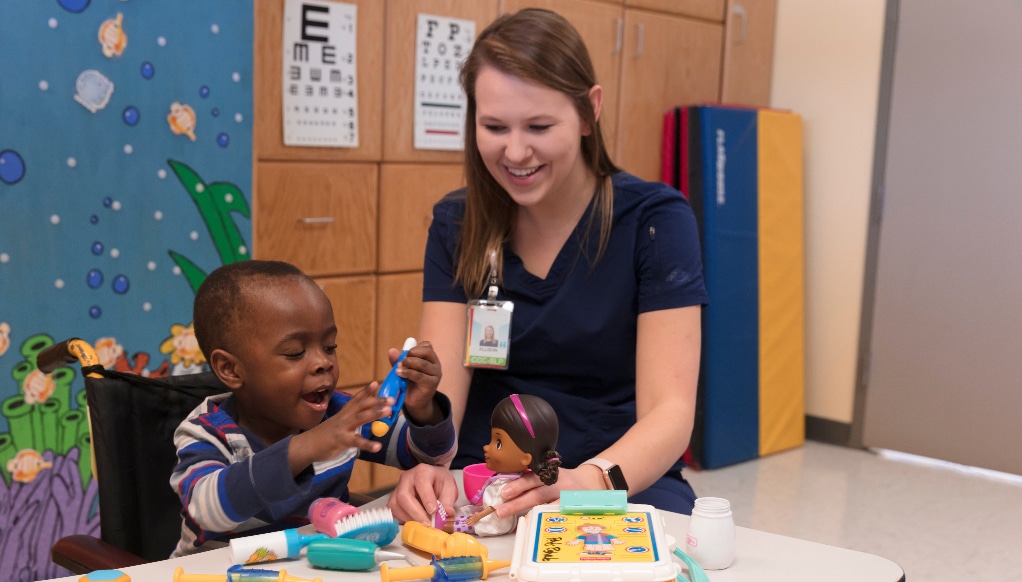 A Maynard Children's Hospital team member plays with a patient during their visit to the hospital.
