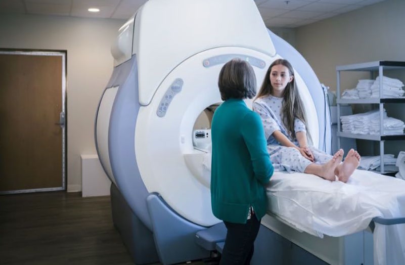 Caucasian doctor talking to patient at scanner