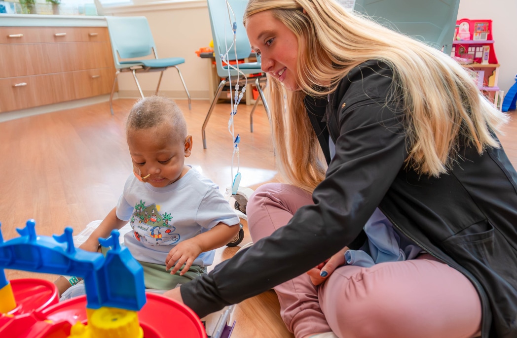 A child life specialist plays with a pediatric patient at Maynard Children's Hospital.