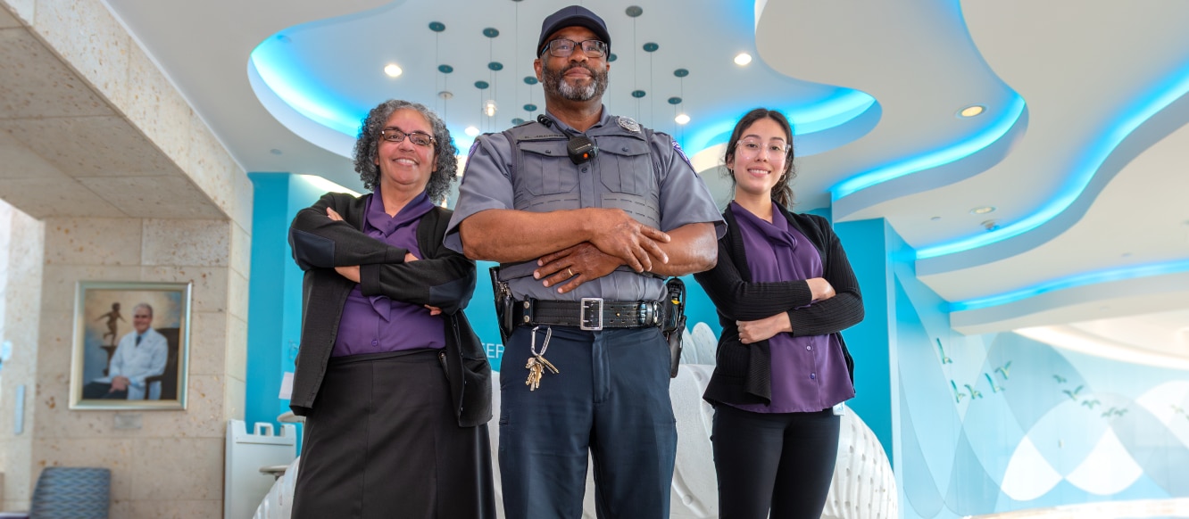 A member of the ECU Health Police team stands with other team members at Reception Reef at Maynard Children's Hospital.