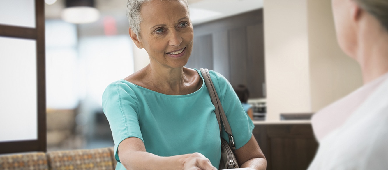 Woman passing insurance card in hospital