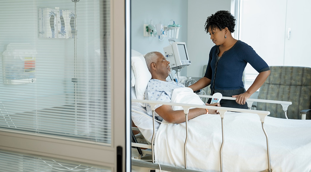 Father and daughter in hospital ward seen through doorway