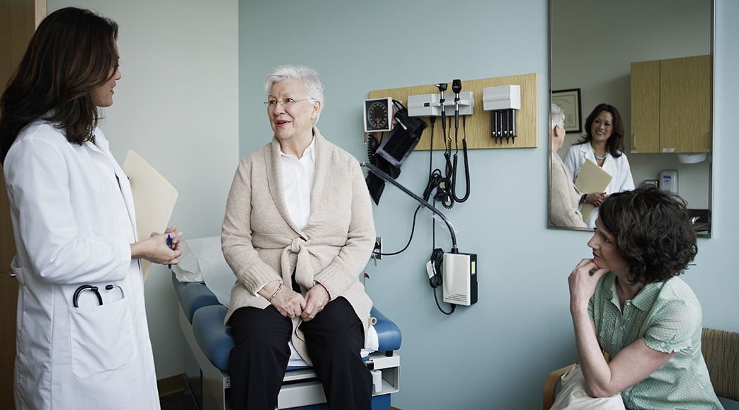 Mature female patient in exam room with doctor