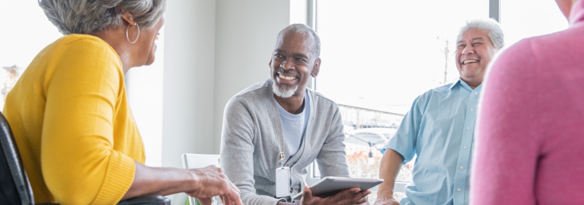 An older group of community members talk with each other during a support group meeting.