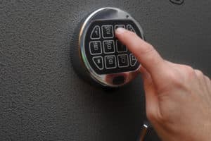 Hand enters combination on a digital lock of a safe's door