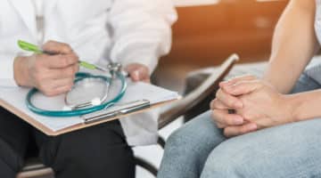 A patient speaks with a doctor during a cancer screening