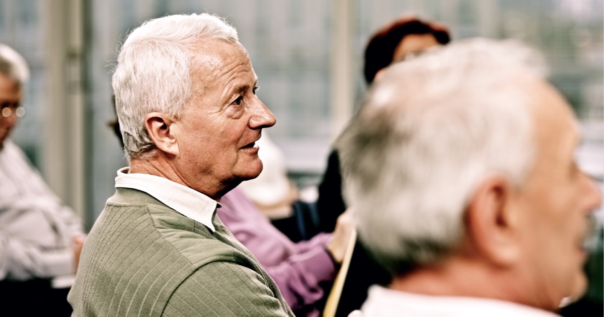 A group of men attend a support group meeting.