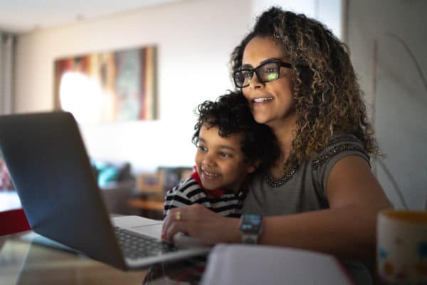 A mother looks at a computer with her son