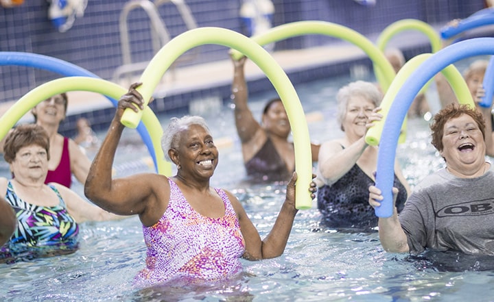 A group of women exercise with water aerobics.