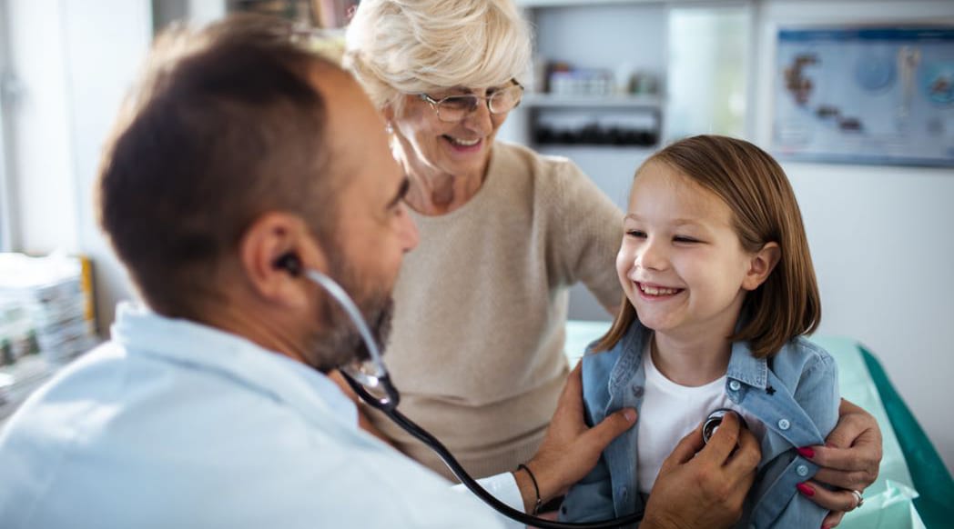 A health care provider examines a pediatric patient.