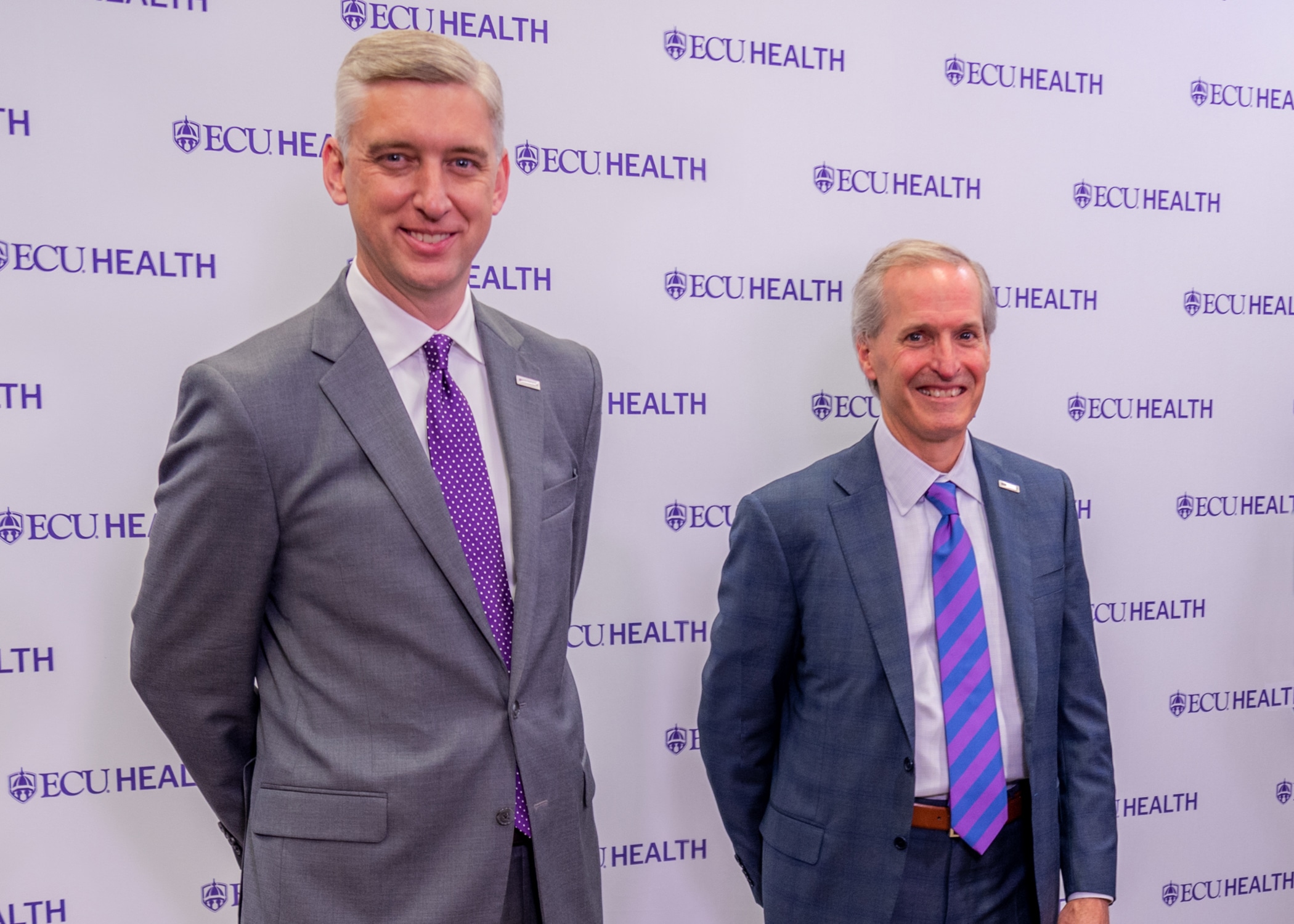 Philip Rogers and Dr. Michael Waldrum pose for a photo after a press conference unveiling ECU Health's new logo.