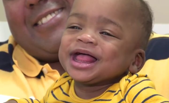 A Children's Miracle Network child sits with their parents at home.