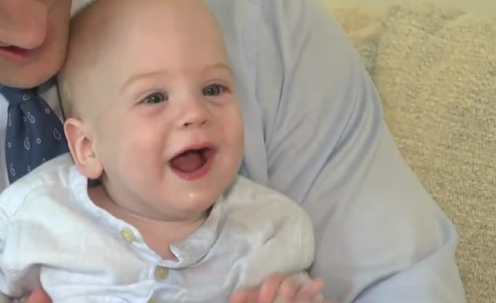 A Children's Miracle Network child sits with their parents at home.