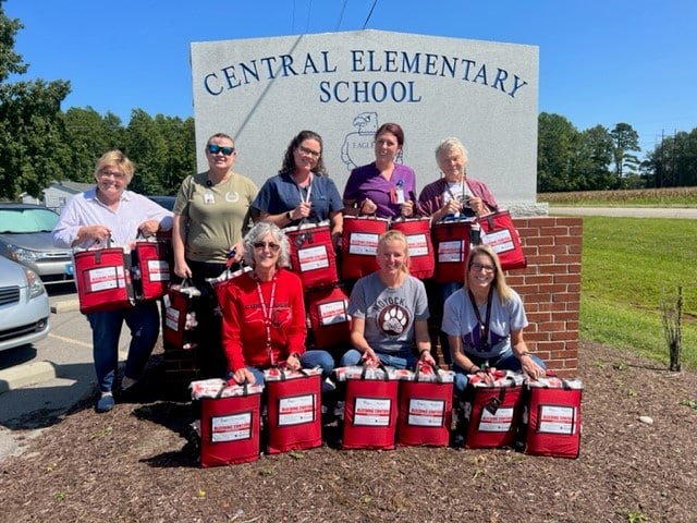 School nurses and other school faculty pose for a photo with Stop the Bleed kits in front of an elementary school in eastern North Carolina.