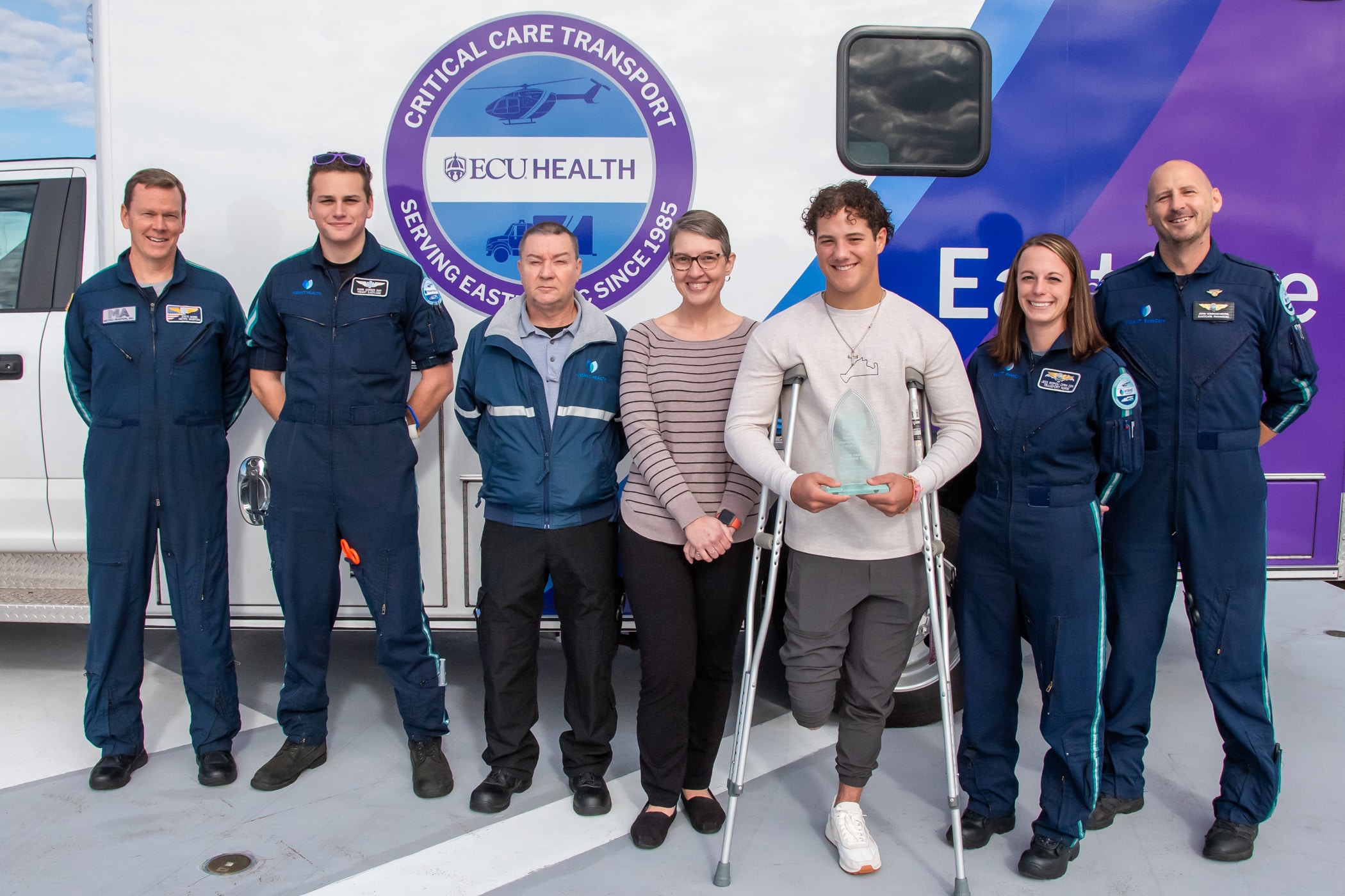 EastCare Award_1 Parker Byrd and his care team pose for a photo outside of an ECU Health EastCare ambulance to celebrate the Patient Transport of the Year Award.
