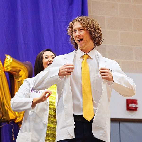 White Coat ceremony on Health Science campus. (ECU Photo by Cliff Hollis) A student at the Brody School of Medicine puts on their white coat for the first time during the 2022 White Coat Ceremony.