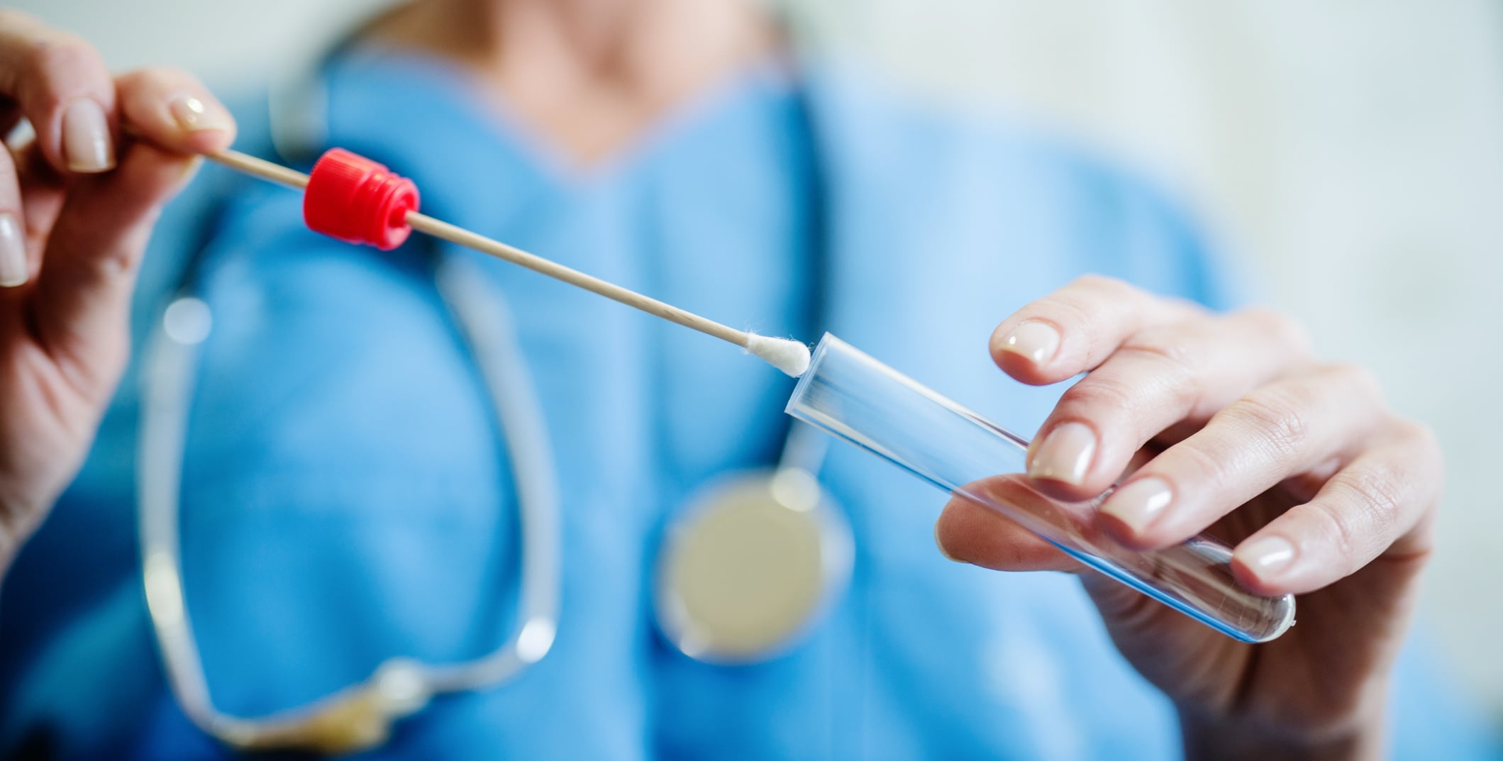 An infectious disease provider fills a test vial.