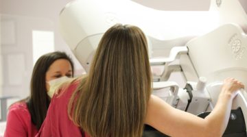 An ECU Health team member assists a patient during a mammogram.