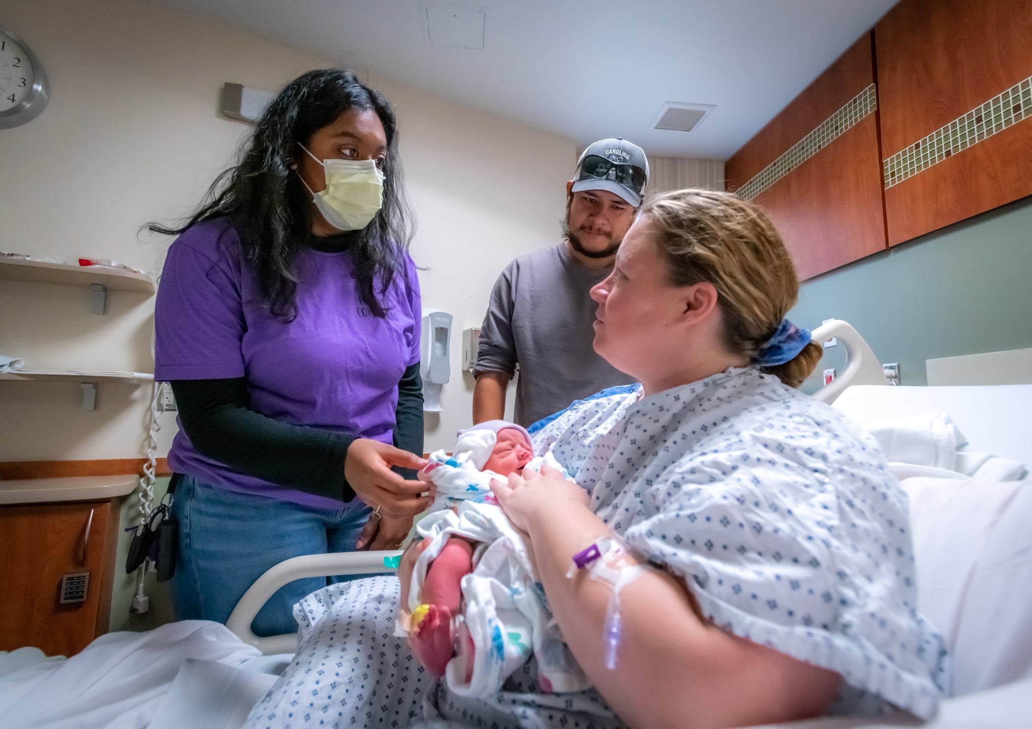 An ECU Health birthing companion speaks with a family after their delivery.