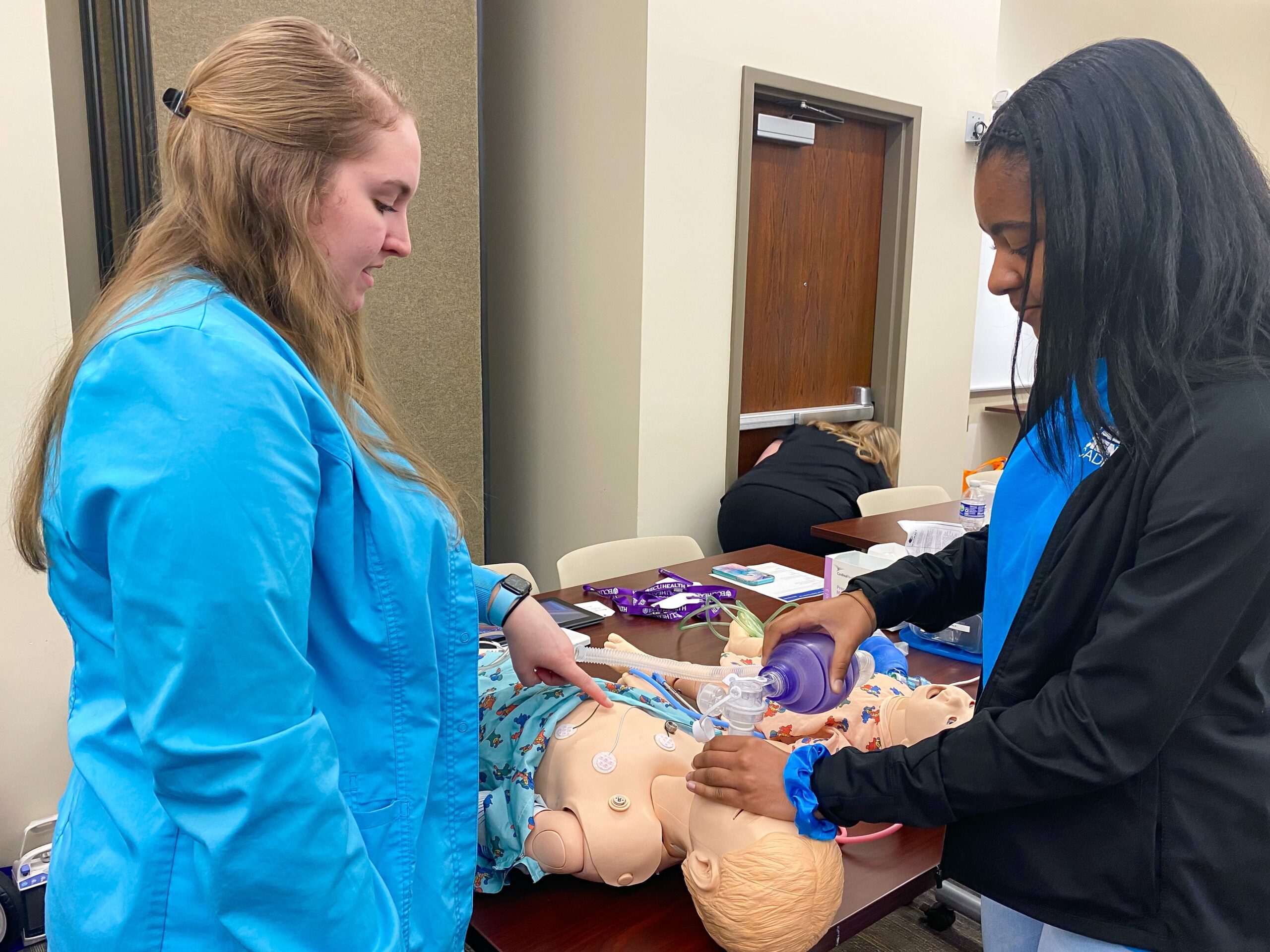 A local student learns about the health care profession from an ECU Health team member during a career fair for Health Sciences Academy students.
