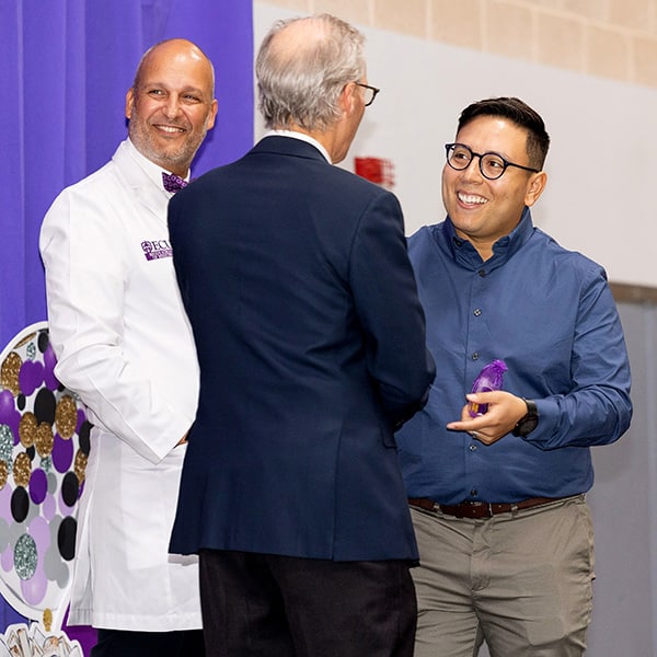 A Brody School of Medicine student shakes hands with Brody Dean and ECU Health CEO Dr. Michael Waldrum during Match Day 2023.