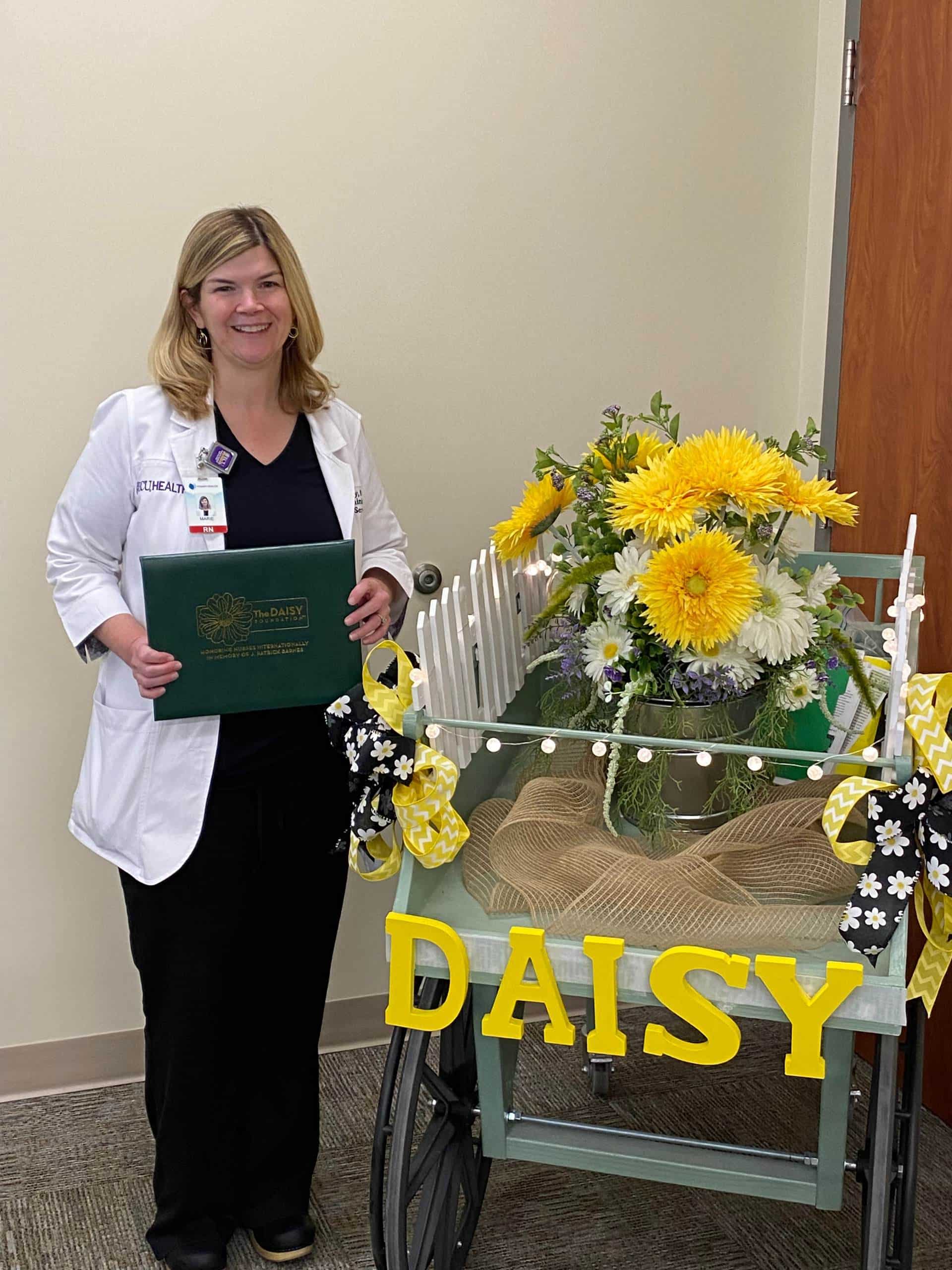 Marie McKinney poses for a photo as she receives the Daisy Leadership Award