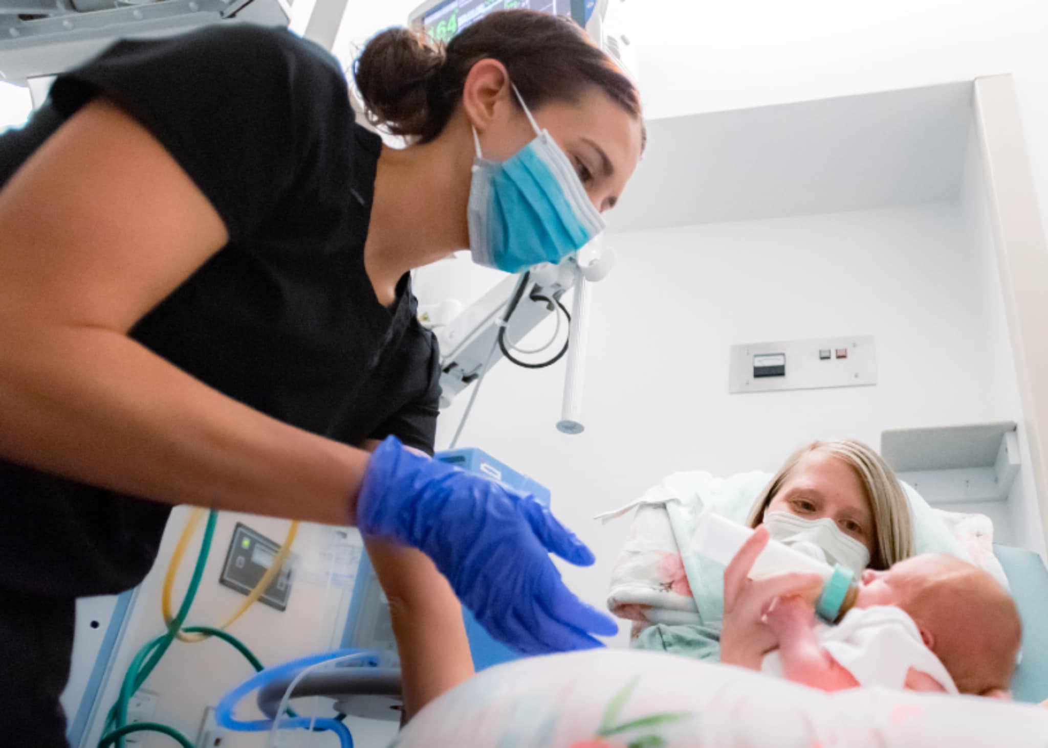 Rhianon Brock-2048 ECU Health nurse Rhianon Brock assists a mother while she feeds her newborn baby.