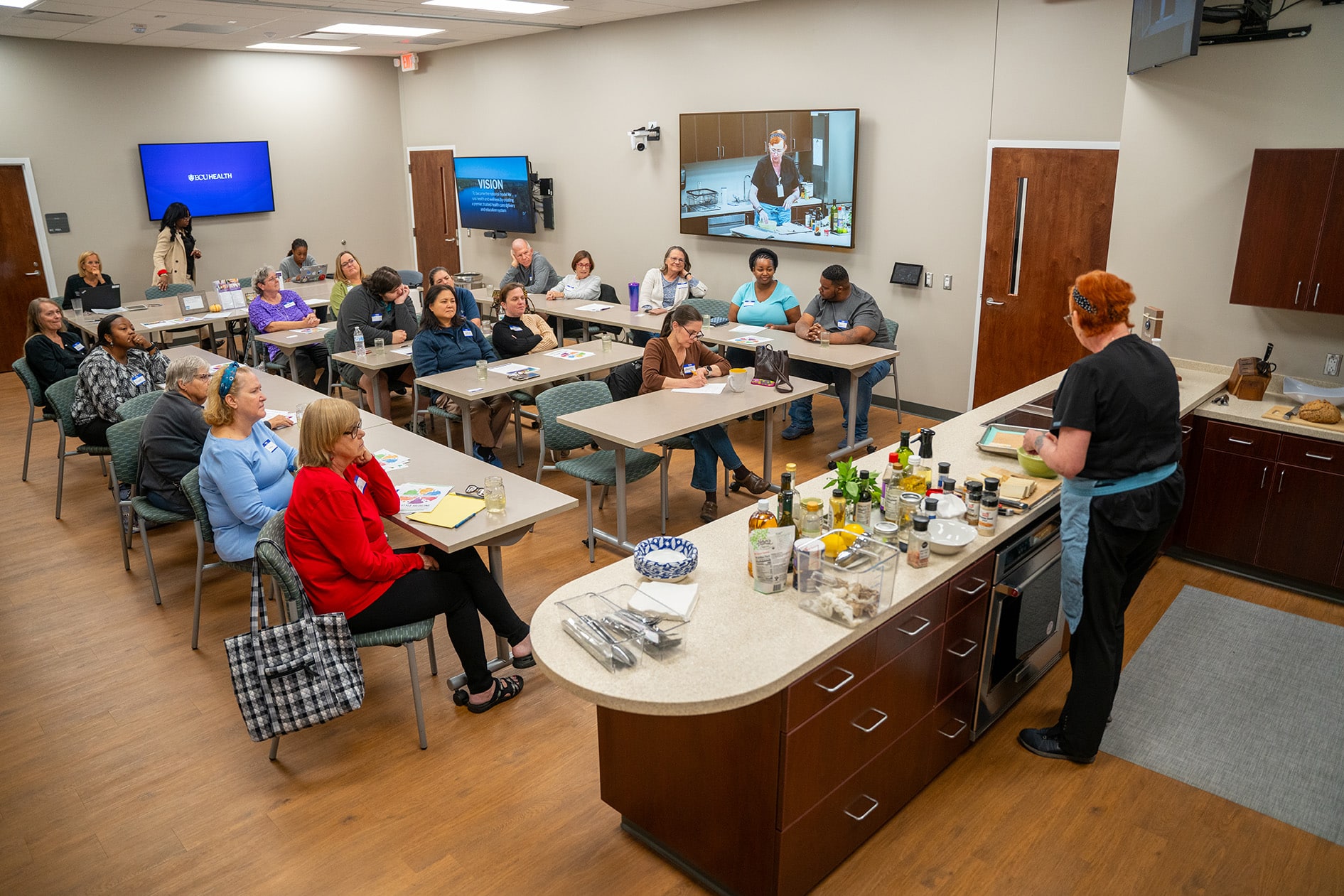 Suzie Houston instructs a Cooking with a Doc class at ECU Health Wellness Center - Greenville. Attendees are instructed on how to cook a healthy meal.