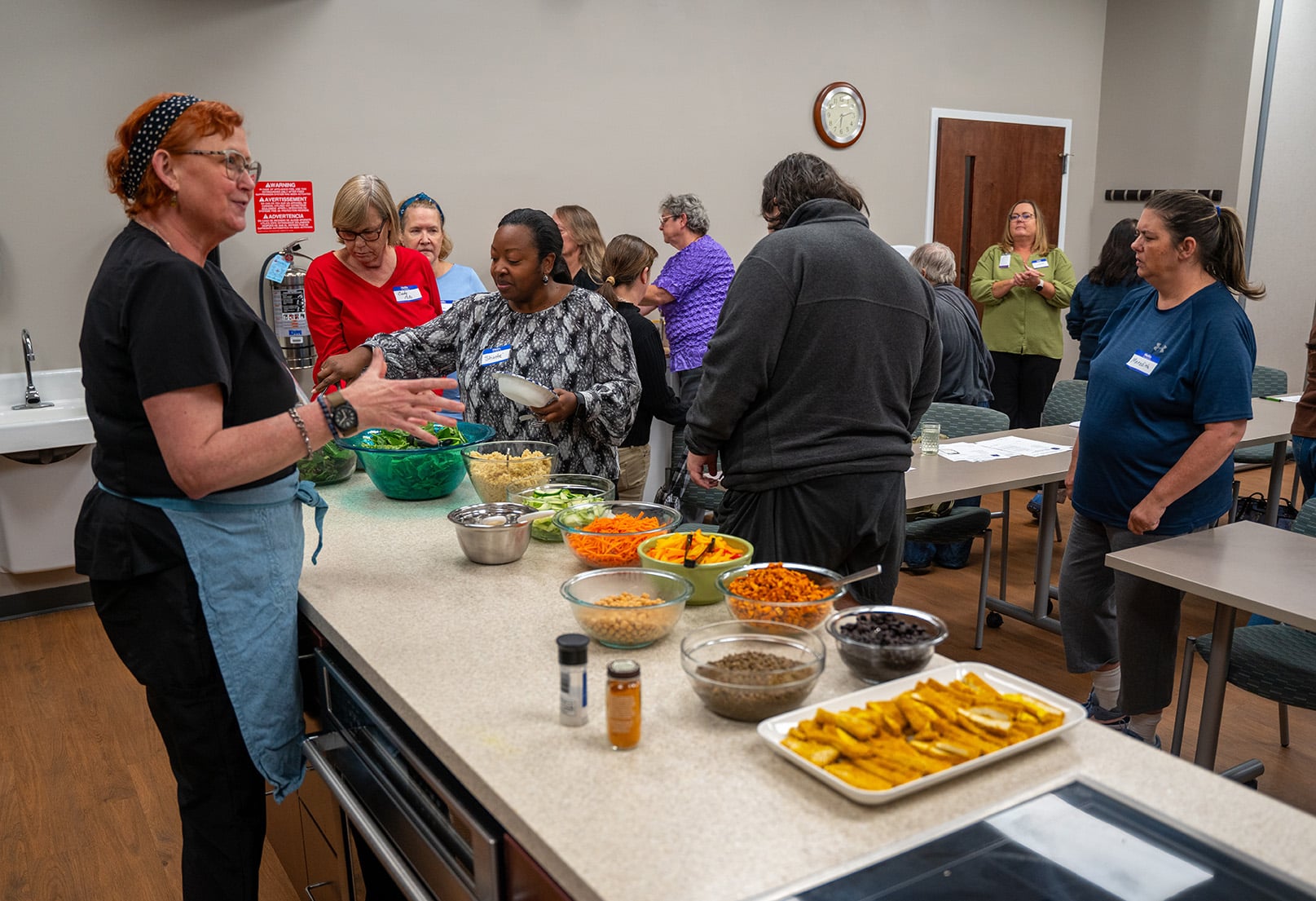 Suzie Houston instructs a Cooking with a Doc class at ECU Health Wellness Center - Greenville. With a healthy meal on the counter, attendees get ready to enjoy a balanced meal.