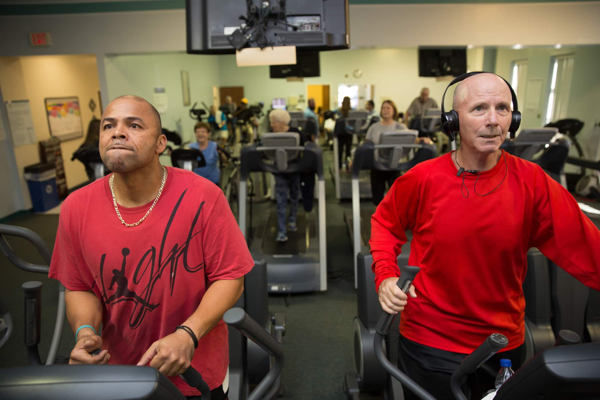 Two men run on exercise machines at an ECU Health Wellness Center.