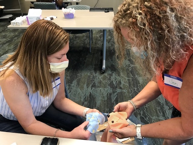 Creating a special face Two ECU Health volunteers work on a memory bear for a family to remember their loved one.