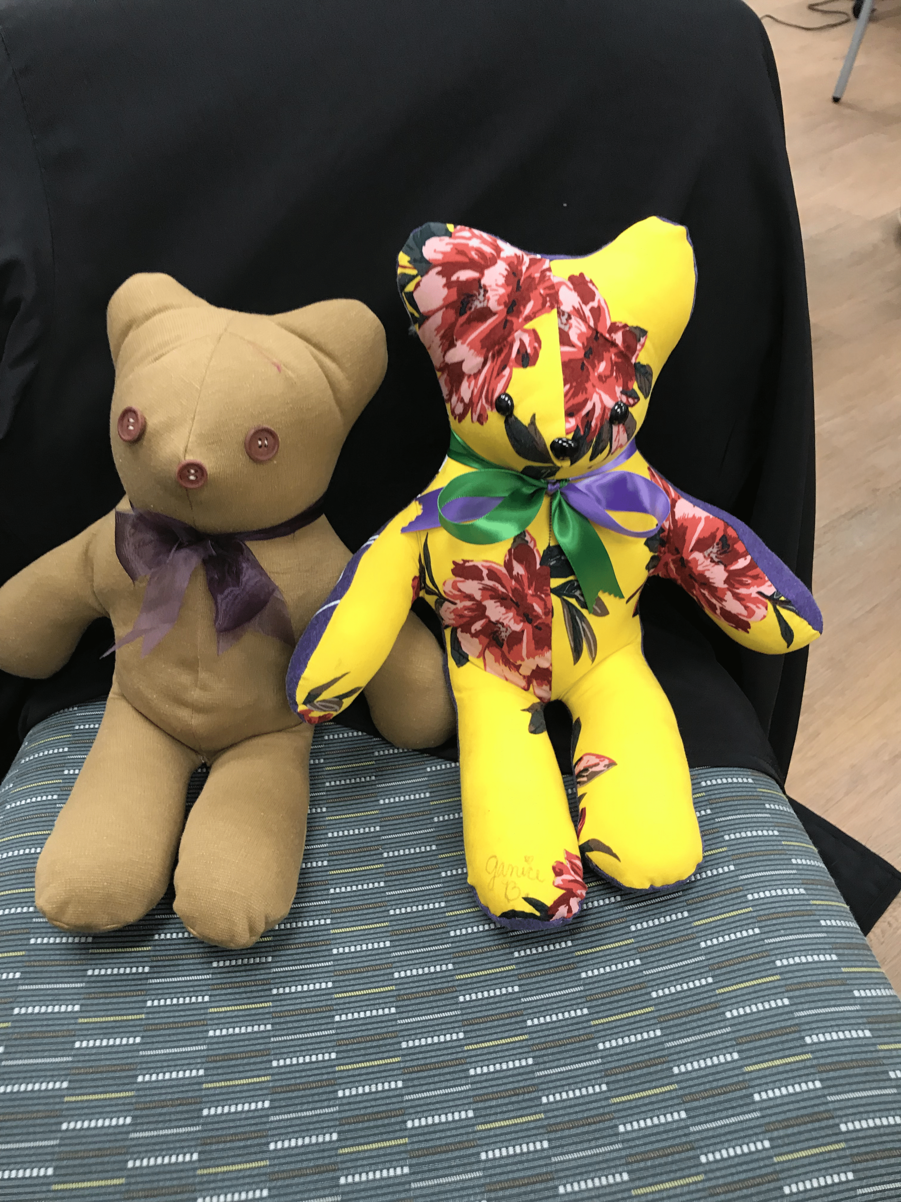 Two memory bears made by ECU Health volunteers sit on a chair, waiting to go home with a family.