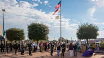 ECU Health team members gather around the flag pole in front of ECU Health Medical Center for a Veterans Day recognition event.