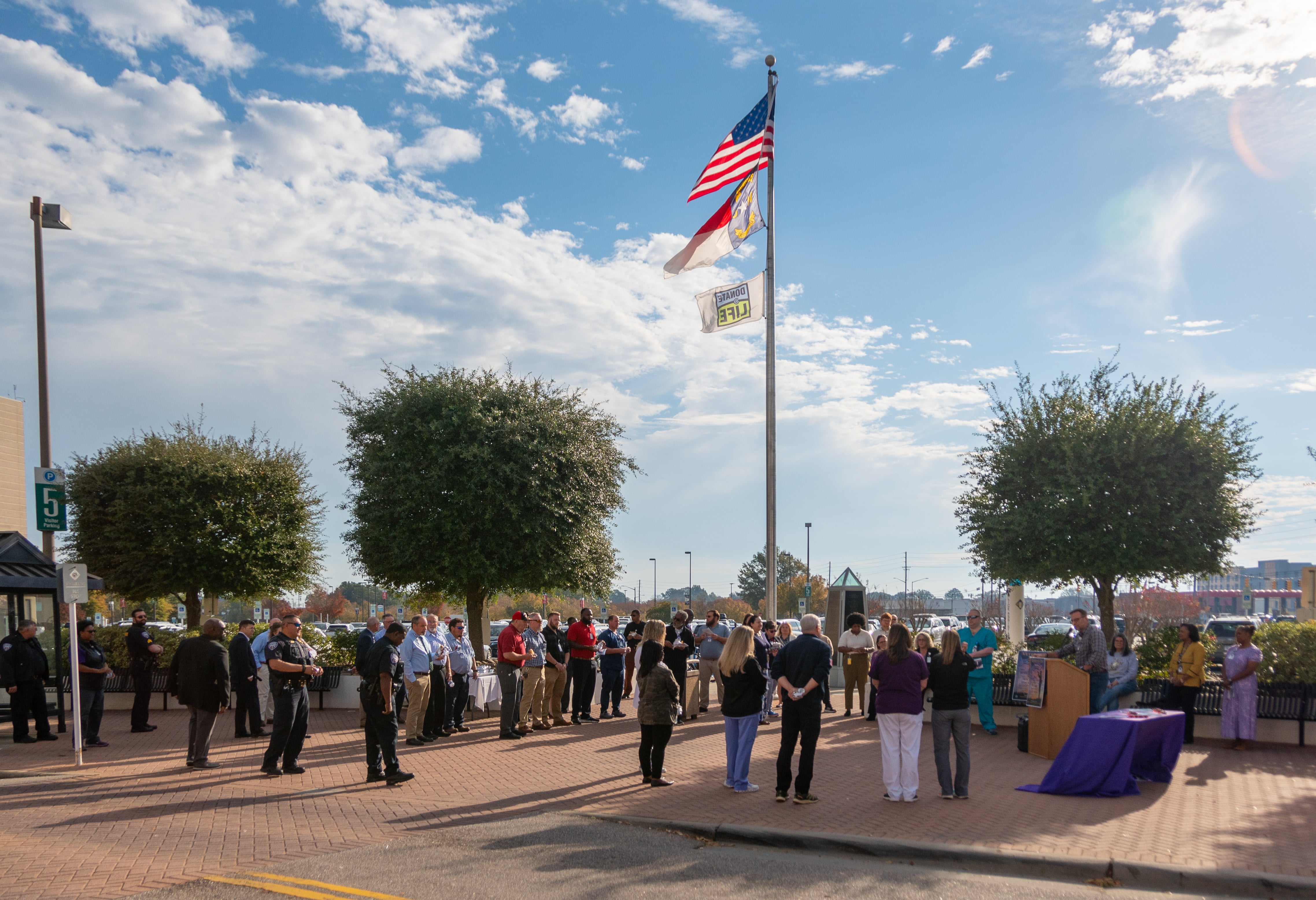 VeteransDay-2023-1429 ECU Health team members gather around the flag pole in front of ECU Health Medical Center for a Veterans Day recognition event.