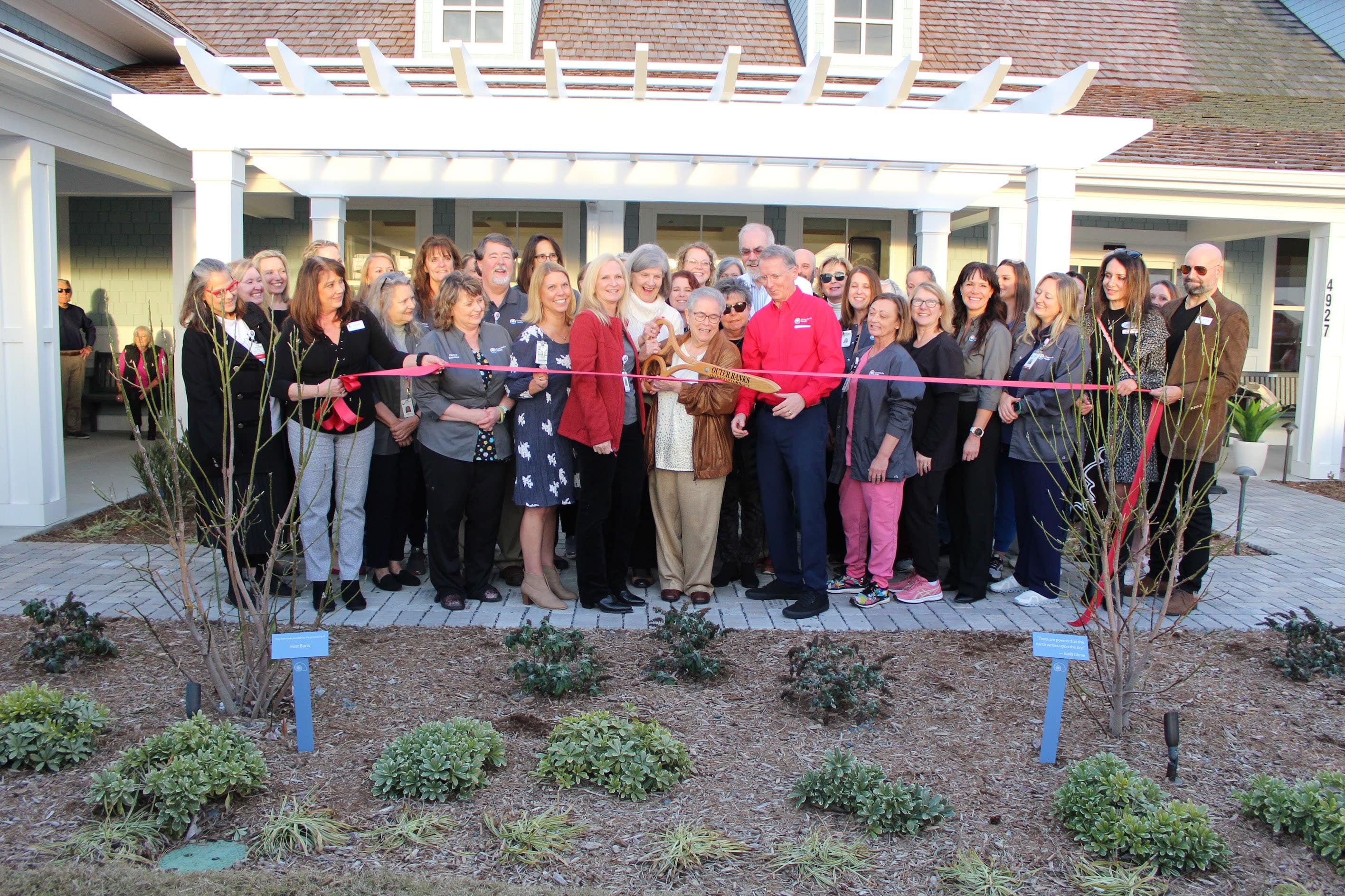 Members of Outer Banks Health leadership and Cancer Services team look on as lead donor Carol Cowell cuts the ribbon for the opening of the Outer Banks Health Carol S. and Edward D. Cowell, Jr. Cancer Center.