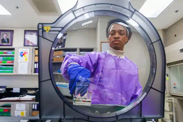 01-22-24-Clinical-Sciences-0103-600 ECU clinical laboratory science senior Bryce Glover loads samples into a gel assay testing console.