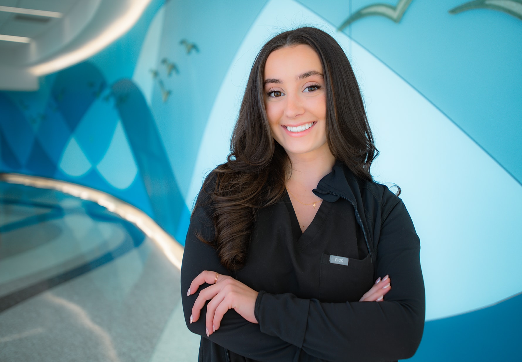 Brianna Cavaliere, a staff nurse in the PICU at Maynard Children's Hospital at ECU Health Medical Center, poses for a photo in a hall at the Maynard Children's Hospital.