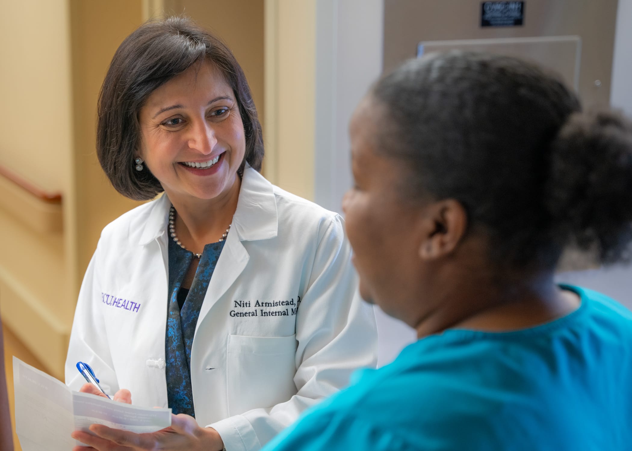 Dr. Niti Armistead, chief quality officer and chief clinical officer at ECU Health, speaks with an ECU Health team member at ECU Health Medical Center.