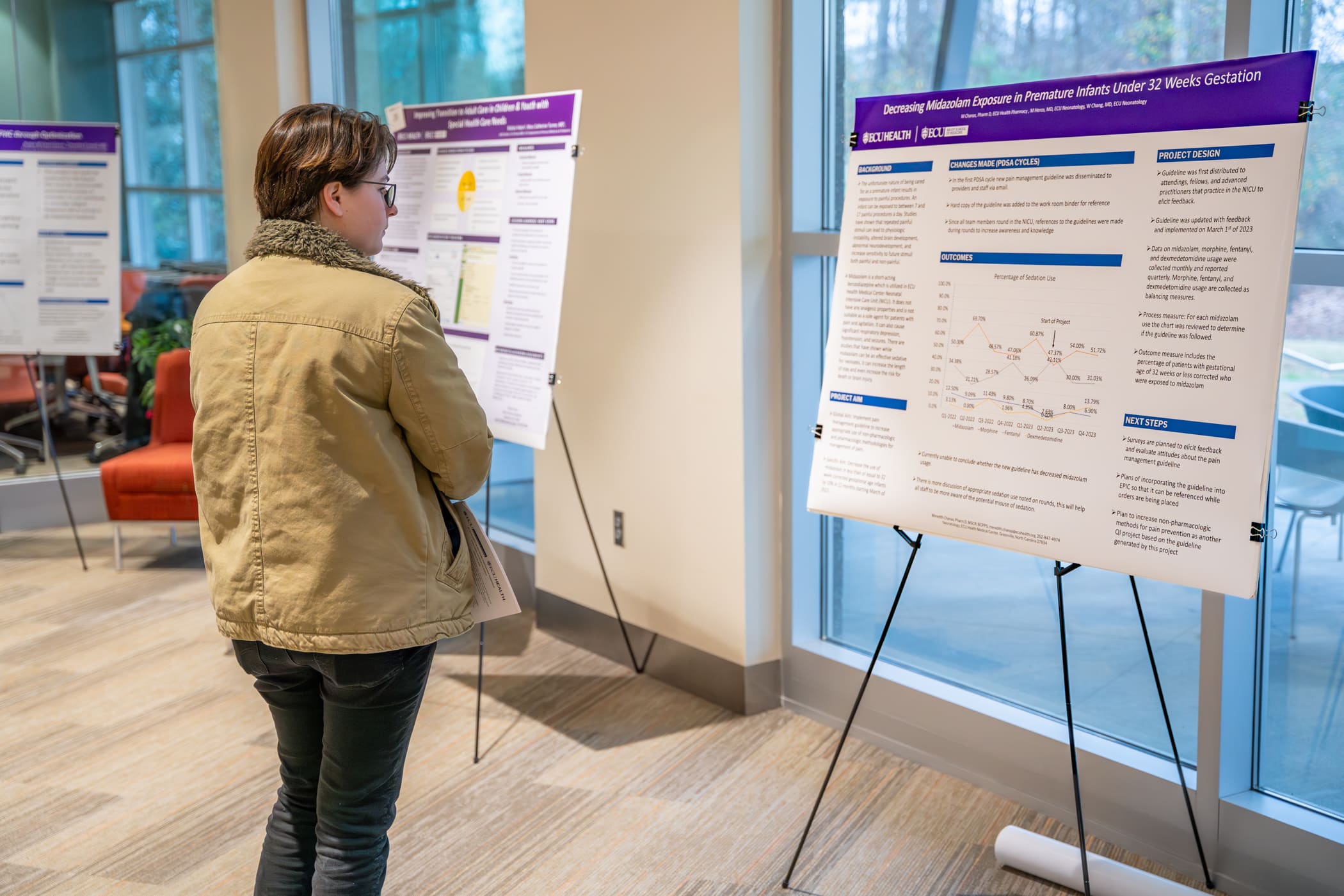 An attendee looks over poster boards of research during the eighth annual Quality Improvement Symposium in 2024.