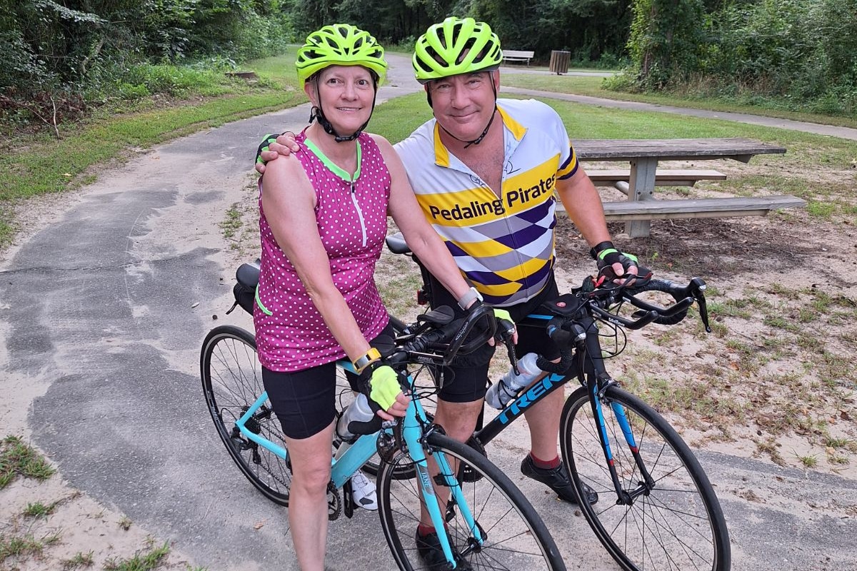 Tony and Delia Parker pose for a photo during a bike ride in Greenville. Tony survived a cardiac arrest during a road race in Greenville in 2021.