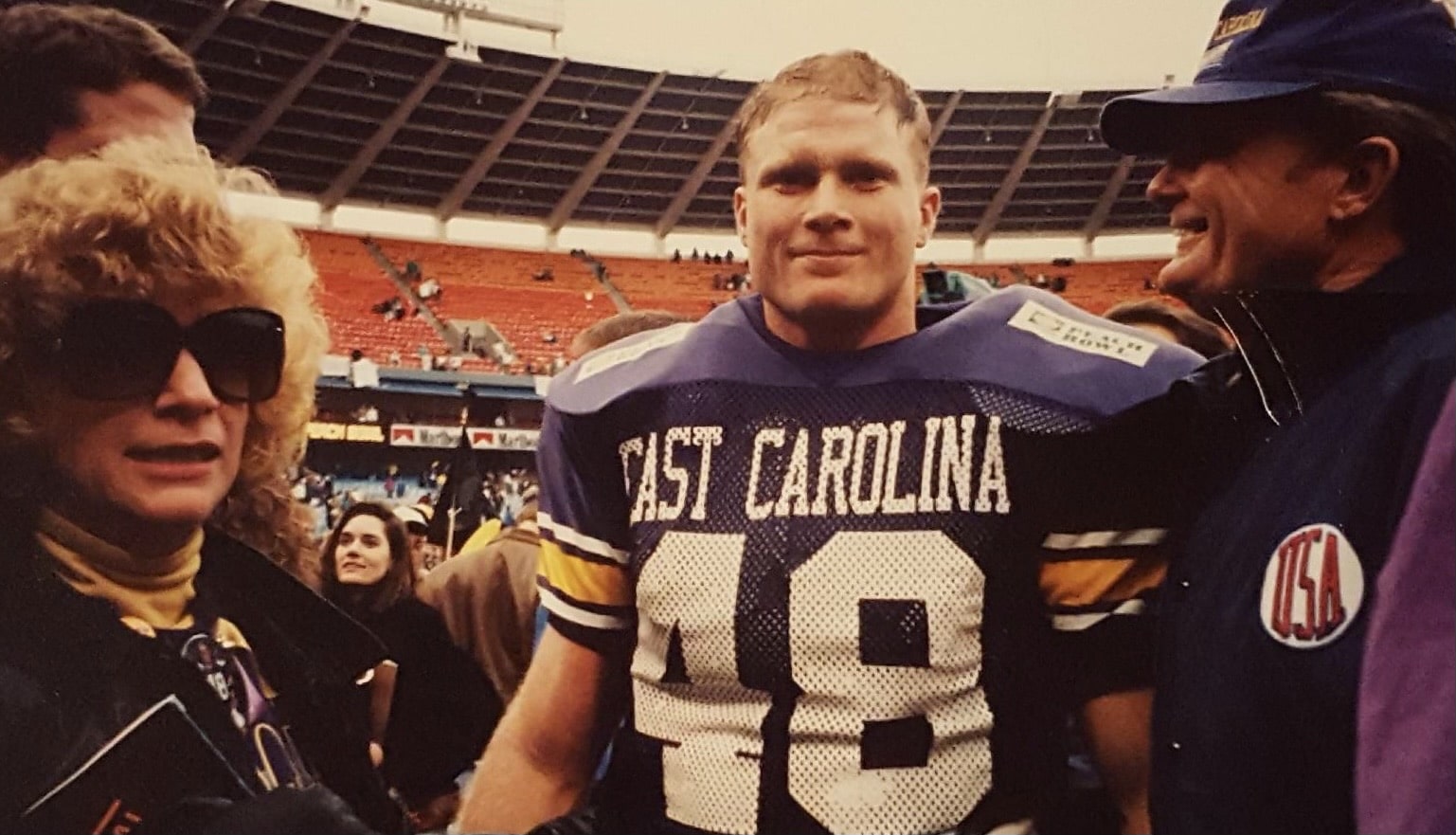 Stephen Braddy, a colon cancer survivor, stands with his family on the field following the 1992 Peach Bowl.