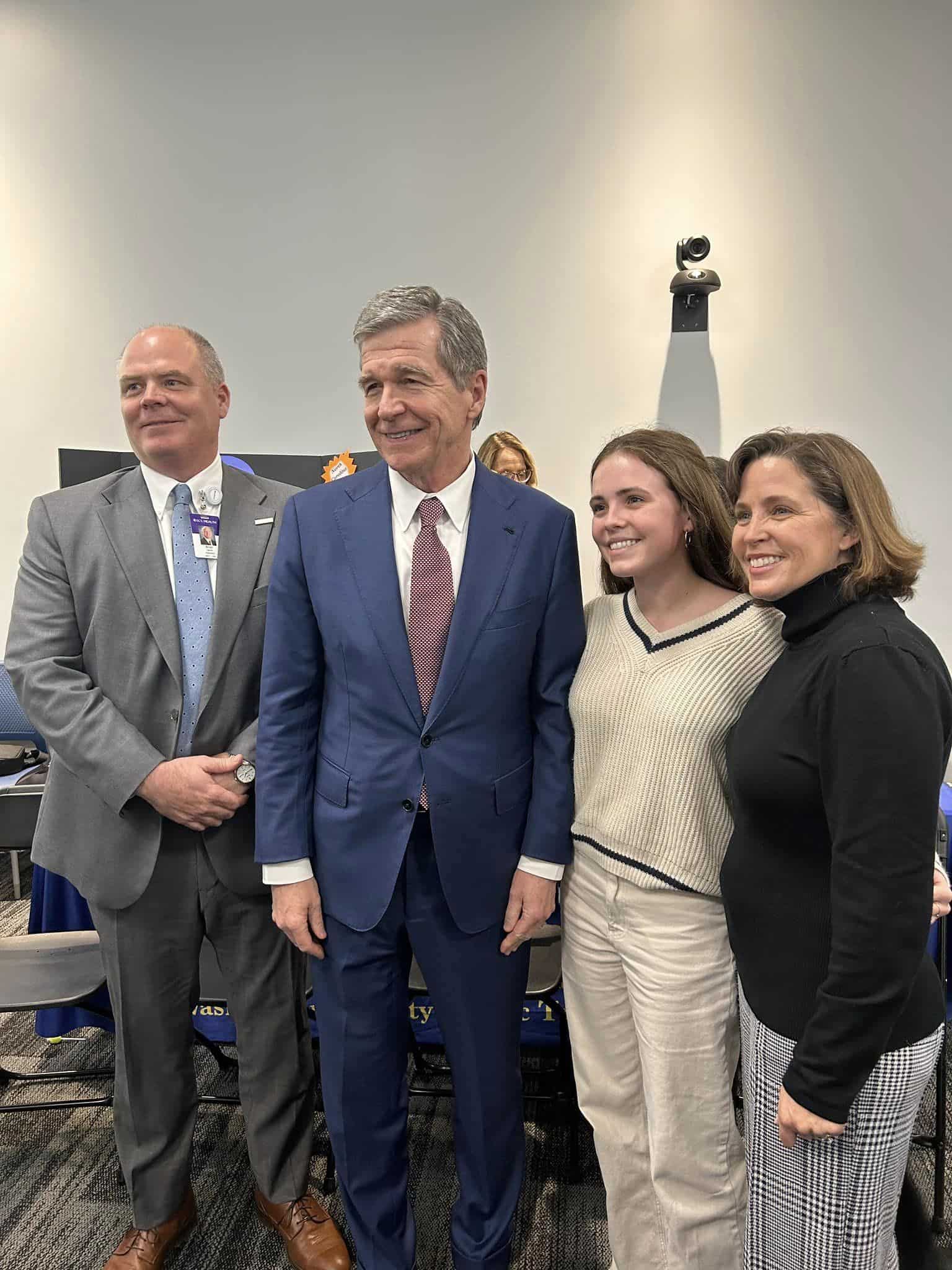 Brian Harvill stands with Gov. Roy Cooper and his family during the Medicaid expansion event in Windsor.