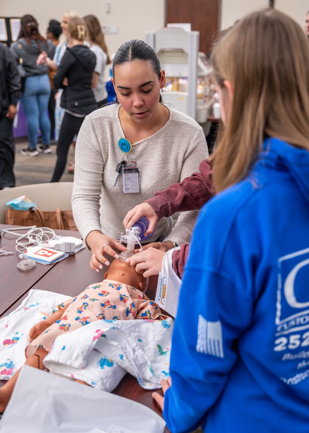 A student watches an ECU Health team member show how to give oxygen to an infant during the Health Sciences Career Fair on March 5, 2024.