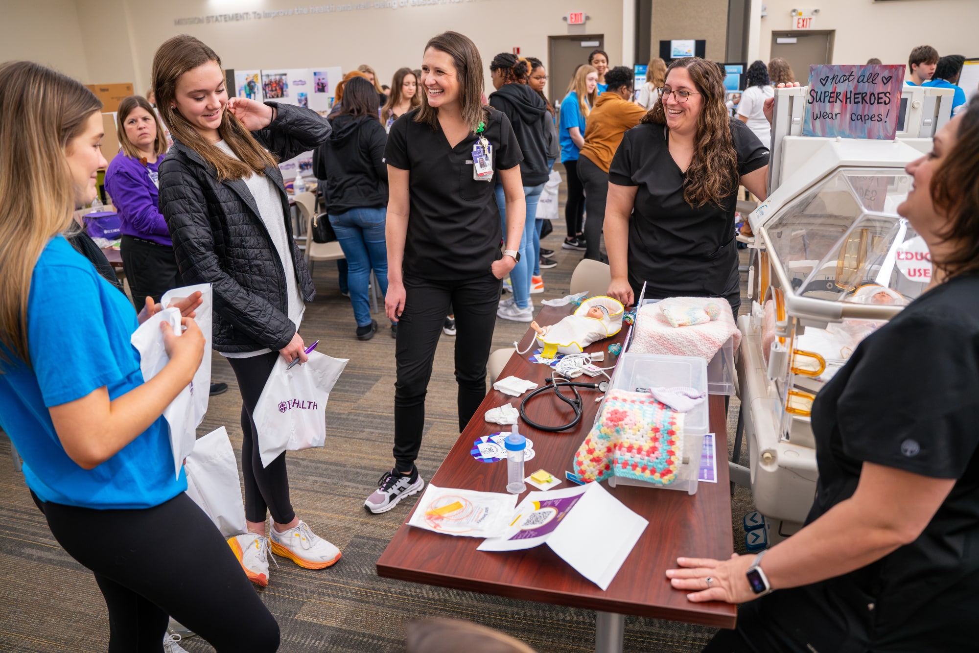 Students discuss a career in health care with ECU Health nurses at a station on pediatric care during the Health Sciences Academy career fair.