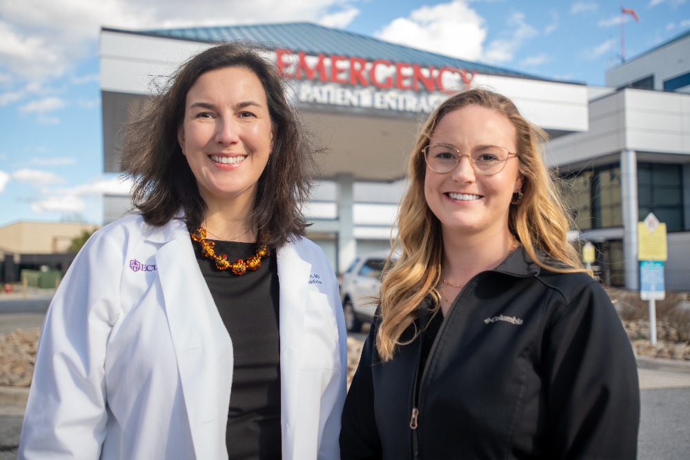 Dr. Leigh Patterson, chief of services for Emergency Medicine at ECU Health Medical Center and chair of Emergency Medicine at Brody School of Medicine at East Carolina University, stands with Alex Baylis, ED nurse manager at ECU Health Medical Center, outside of the Emergency Department at ECU Health Medical Center.